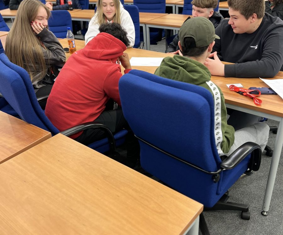 A group of young people sit around a table deep in discussion