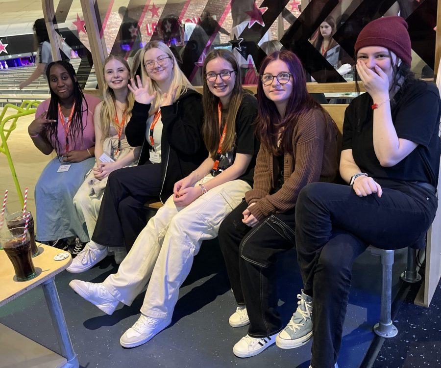 Young people sitting at a bowling alley