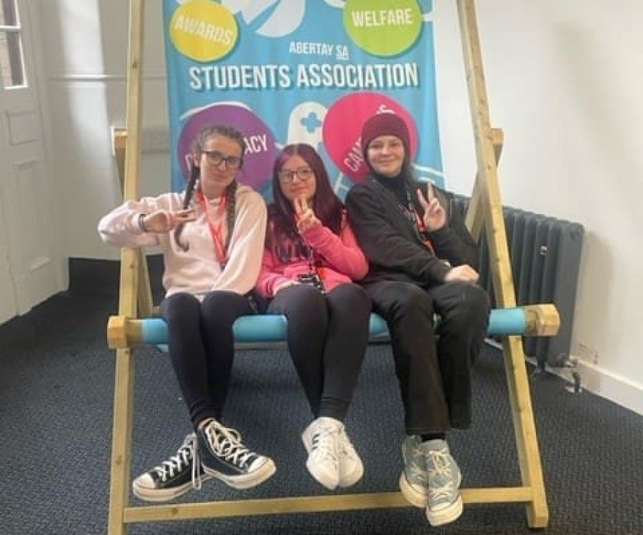 3 girls sitting in a giant deck chair